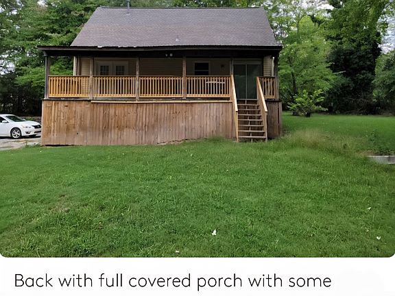Back of house with full covered deck with storage