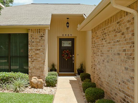Inviting covered front porch with a beautiful leaded glass front entry door and recently updated lighting.