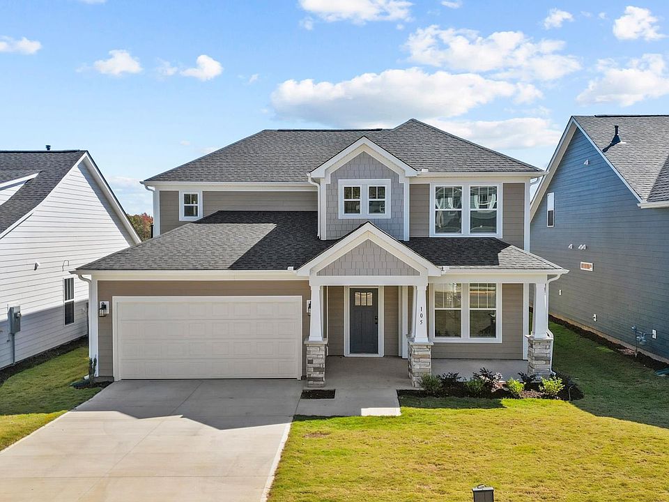 Two story home in Greenville, SC with neutral exterior, two car garage, and stone columns at Pelham