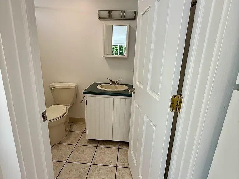Bathroom if off of the kitchen, with plenty of light and storage.