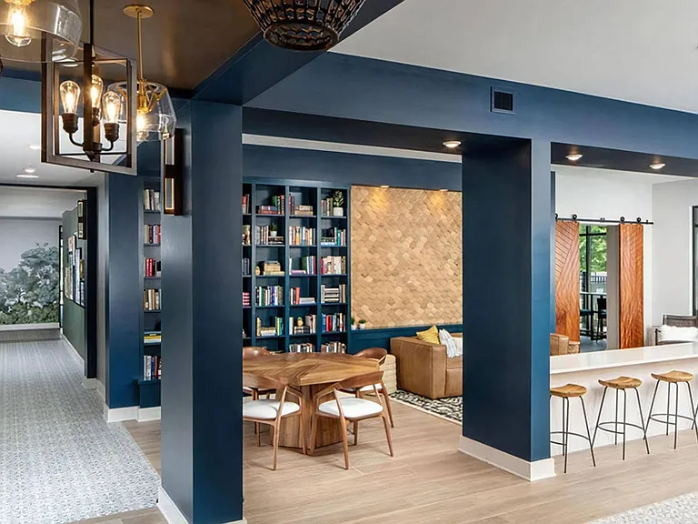 Stylish Community Clubhouse Featuring Built-In Bookcases, Work Tables, and Bar Seating