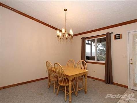 Freshly painted dinind room with cathedral ceiling, crown molding, and overhead light. Walk out to covered rear deck