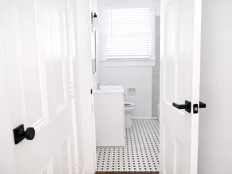 Updated bathroom featuring classic tile flooring, a refreshed vanity, and bright, modern finishes
