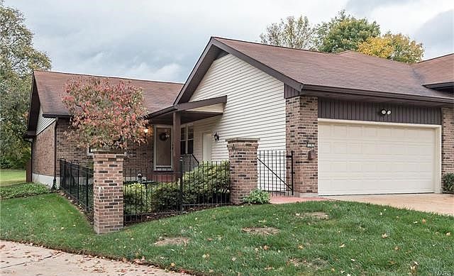 1282 Coral Bells Ct. in sought after Parkway Gardens Village has a private front entry courtyard that is fenced with wrought iron and brick pillars.