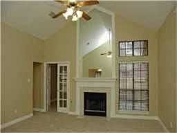 Columns open to the oversized den which has a high ceiling, floor plugs, and a tiled gas log firepla
