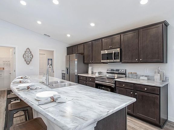 Open kitchen with a large counter-height island and your choice of finishes - Raychel home plan by H