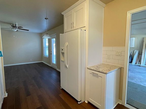 Looking from kitchen into den/dining/bonus room. Door in front of the photo leads to garage.