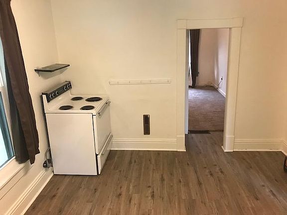Large kitchen with new flooring. Looking into the living room/bedroom.