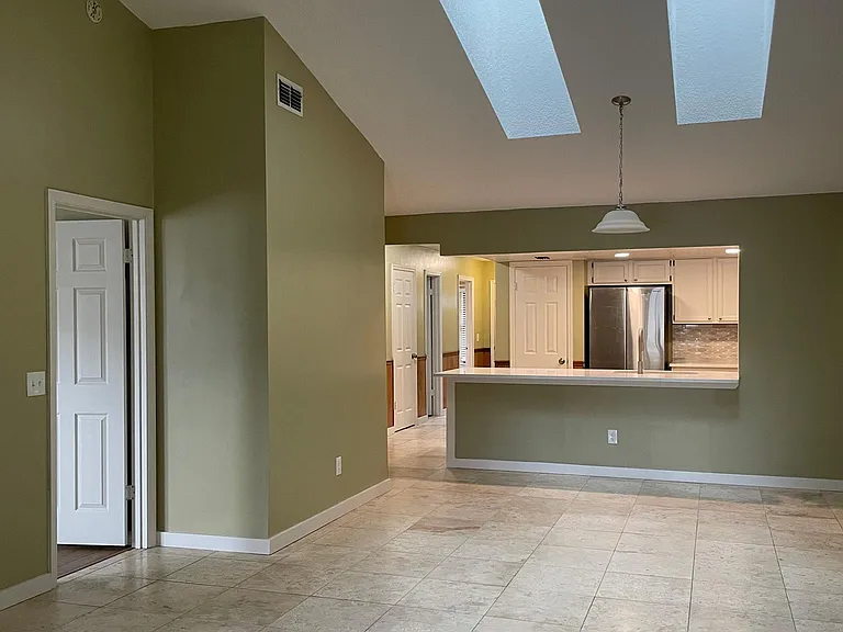 View from patio into family room and kitchen. Light fixtures are all brushed nickel