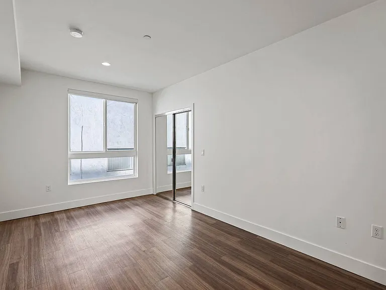Bedroom with a Mirrored Closet, Vinyl Flooring, and Windows