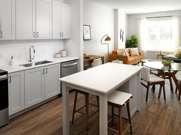 New West Phase - Finish Package III Kitchen with stainless steel appliances, white quartz countertops, grey cabinetry, and hard surface flooring throughout