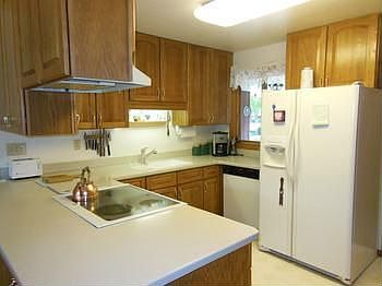 Solid surface counters and beautiful oak cabinets that reach the ceiling are highlights of this functinonal kitchen.