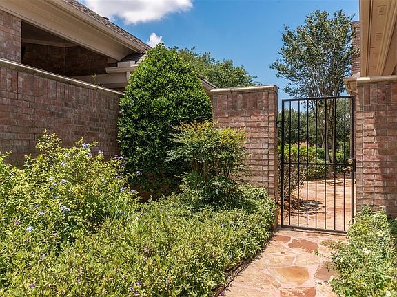Landscaped and gated side yard is viewed from the living area.