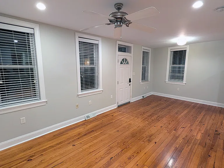 The living space at night. It is lit with recessed lighting and has a ceiling fan. The walls and second-floor ceiling are fully insulated.
