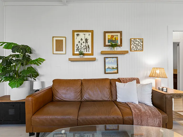 The living room includes an Italian leather sofa and loveseat and one chair, TV, ceiling fan, windows and an AC unit. The living room opens to the lanai and blends seamlessly with the kitchen.
