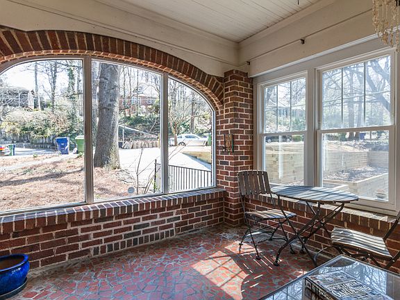 Enclosed sunroom with two walls of full windows and original patio tile