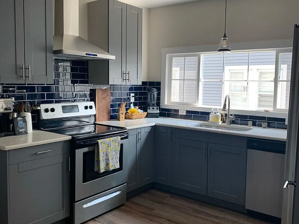 Kitchen with new cabinets, stainless steel appliances, tile backsplash. window faces driveway. No garbage disposal.