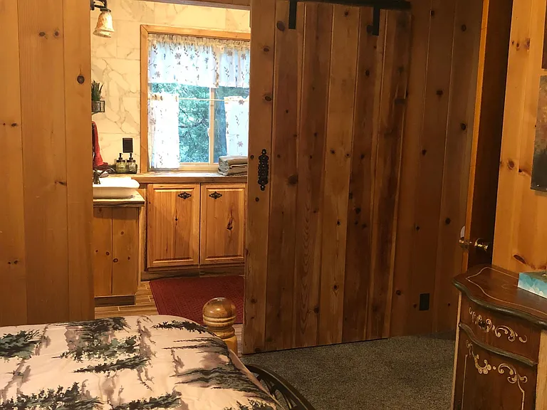 There are two entrances into the bathroom, one from the foyer and a barn door from the bedroom.
