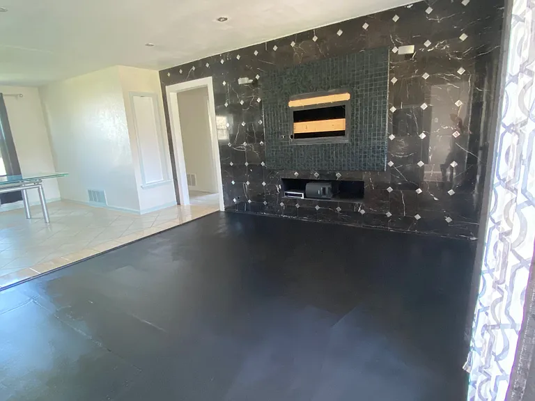 Spacious living room has tiled wall and TV mount already in place.