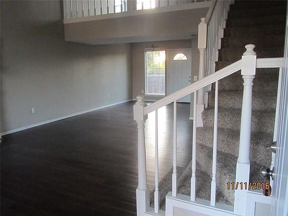 View of living area with new wood flooring and stairs with new carpet from main entry.
