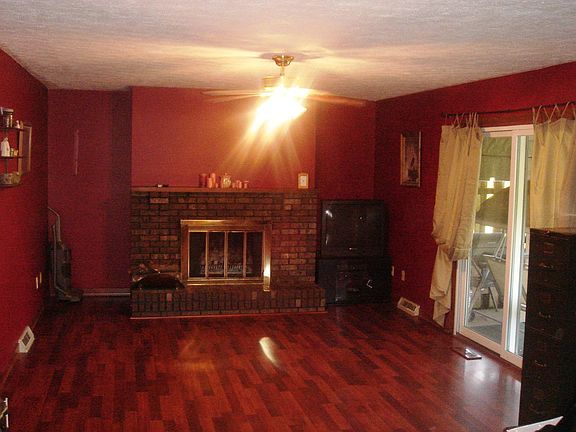 Warm, cozy family room is dominated by the lovely brick fireplace. 