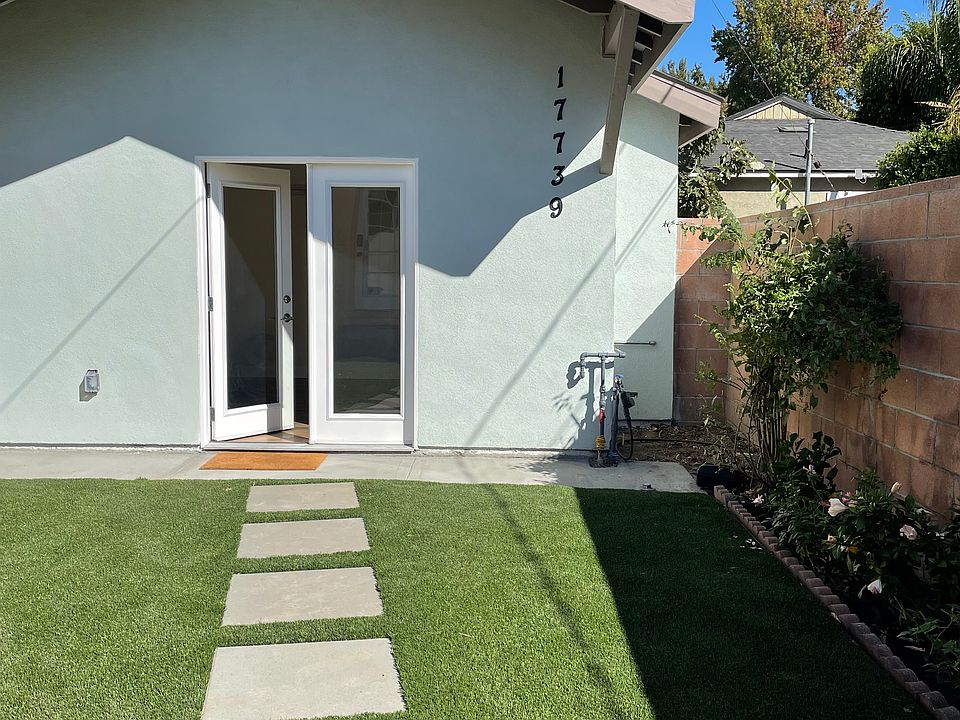 Walkway with flat concrete pavers embedded in lush green turf of highest quality