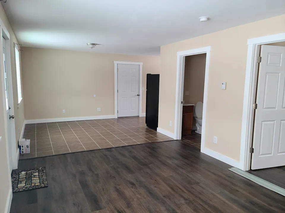 Looking from livingroom toward dining area straight ahead and kitchen far down on the right. 
Door to garage straight ahead. 
Door to outside on left. 
1st door on right is bedroom. 
2nd door on right is bathroom.