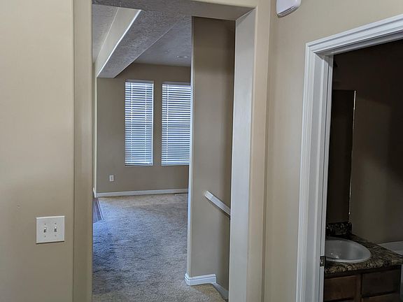 Entry way from front door showing bathroom on right. 
Coat closet is on left beyond camera with washer and dryer in another closet across from bathroom.
Kitchen and great room toward back of hallway