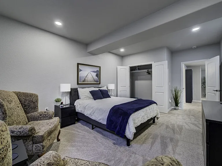 Queen Bedroom
Downstairs bedroom with queen bed, smart TV, two armchairs, dresser, and closet