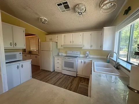 Kitchen with pots, pans, cooking utensils, plates, glasses, flatware, coffee maker, and toaster. Ready to go!