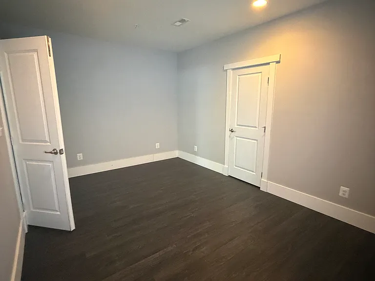 Bedroom #5 in the walk-out basement features a closet and offers flexible use as a guest room, home office, gym, or hobby space.