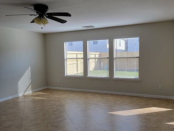 Living Area with ceiling fan and beautiful windows, blinds throughout the home as well.