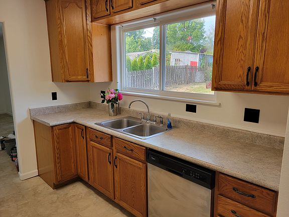 Kitchen, dishwasher and sink. Looks out to fenced back yard.