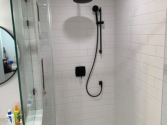 newly updated walk-in shower in bathroom connected to the primary bedroom. Rain showerhead and detachable wand showerhead pictured