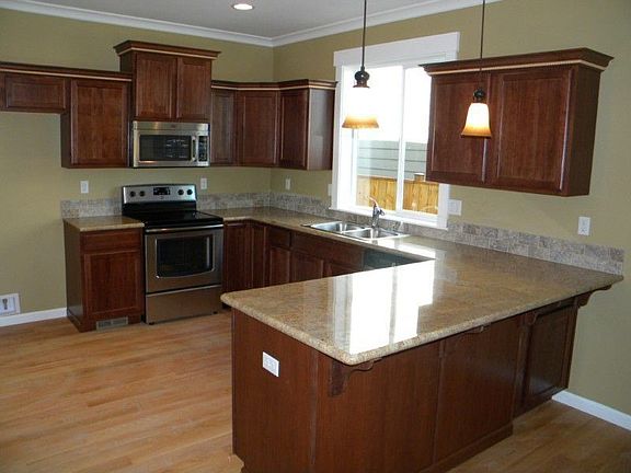 Beautiful kitchen with hardwood floors, slab granite counters and stainless steel appliances.