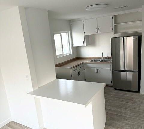 Kitchen with small breakfast bar and side door entrance to parking spaces for easy grocery hauls.