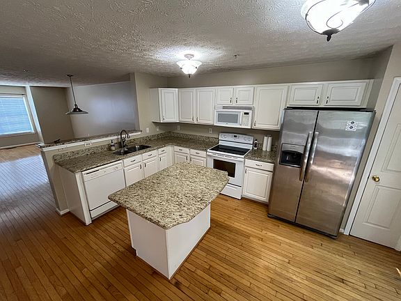 View from kitchen with pantry open to dining and living area
