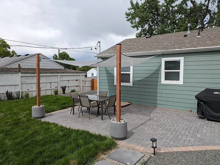 Spacious paver patio installed 2022 with necessary hardware and posts for shade sail.