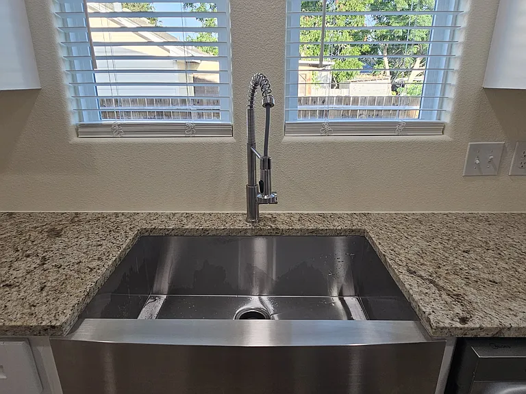 Big farmhouse sink with a sprayer and garbage disposal