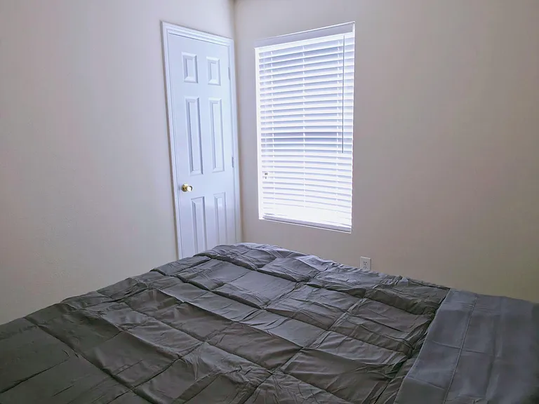Private bedroom featuring a ceiling fan with light, a window with blinds, and space for a full/queen bed and essentials.