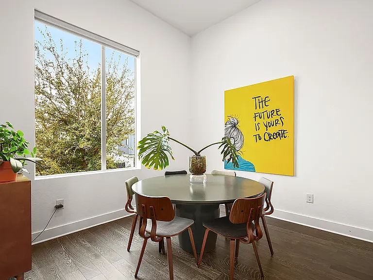 The dining area overlooks oversized windows that flood the space with natural light, creating the perfect setting for everyday meals or hosting friends.