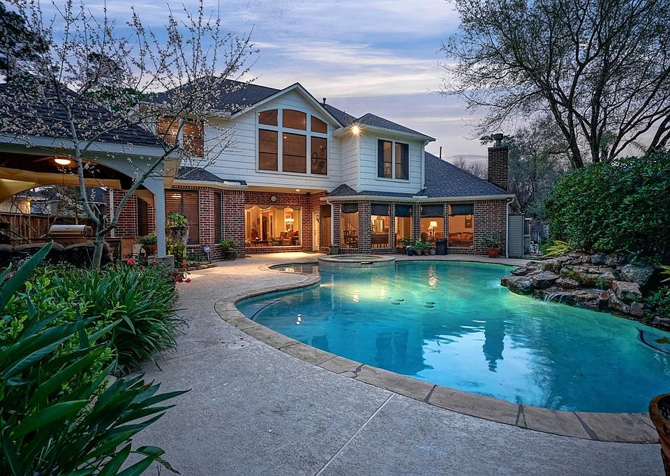 This Champions Centre Estates home is located in a cul-de-sac and features a large backyard with sparkling pool, waterfall and pavilion with summer kitchen.