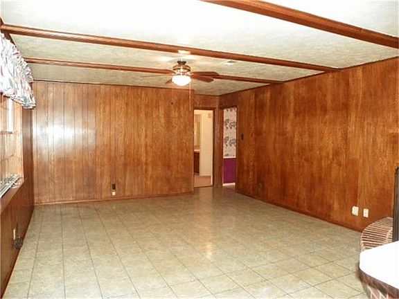 Large tiled den with wood paneling.
