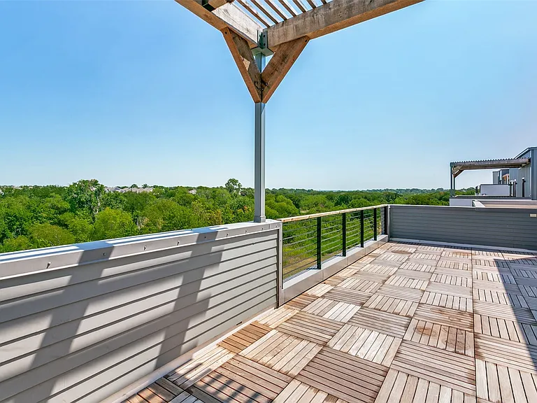 Expansive third-floor outdoor retreat featuring a covered pergola and peaceful views, perfect for entertaining or unwinding.