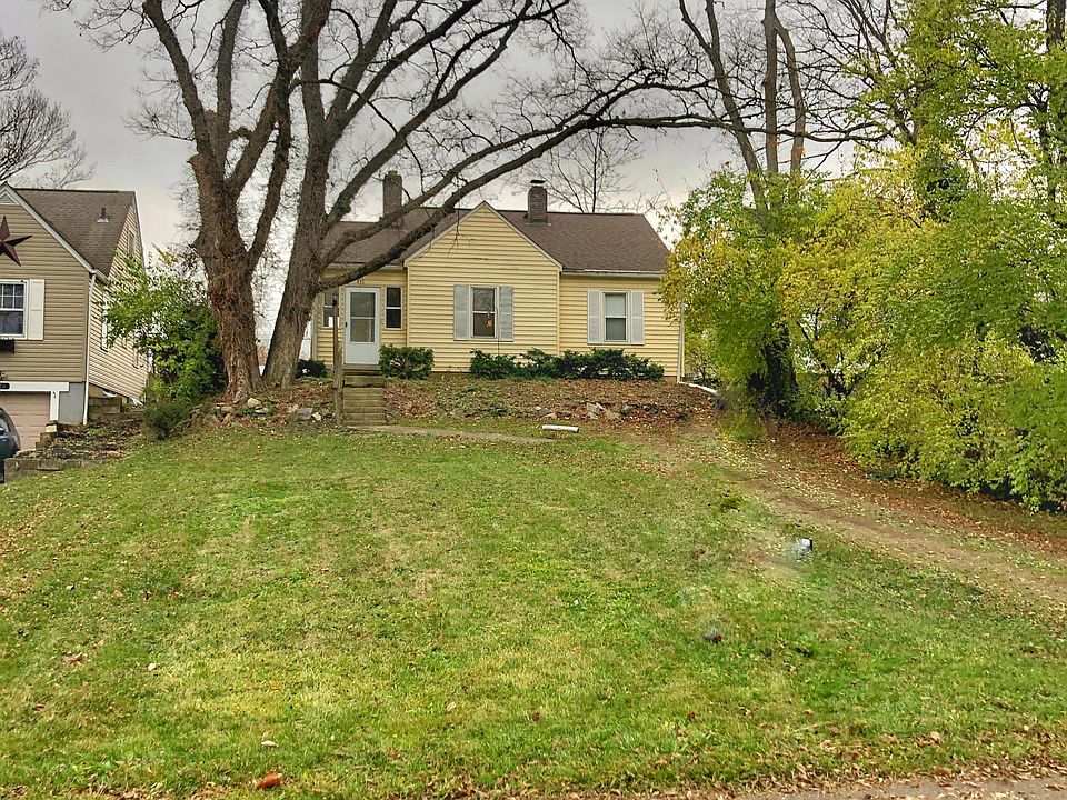 Front view of the ranch style cottage, showing the large yard and long driveway for additional off street parking. The police station is across the street.