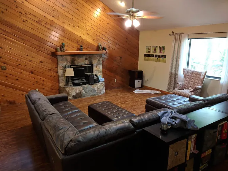 Extra large living room with wood burning fireplace and vaulted ceilings. Large picture window and skylights allow lots of natural light into the house