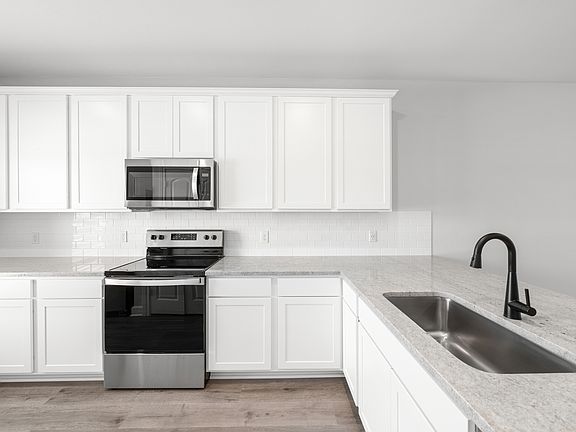 The kitchen of the Driftwood has beautiful white-wood cabinetry.