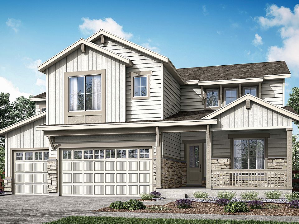 A two-story residential house with a garage, surrounded by landscaped gardens and a clear blue sky w