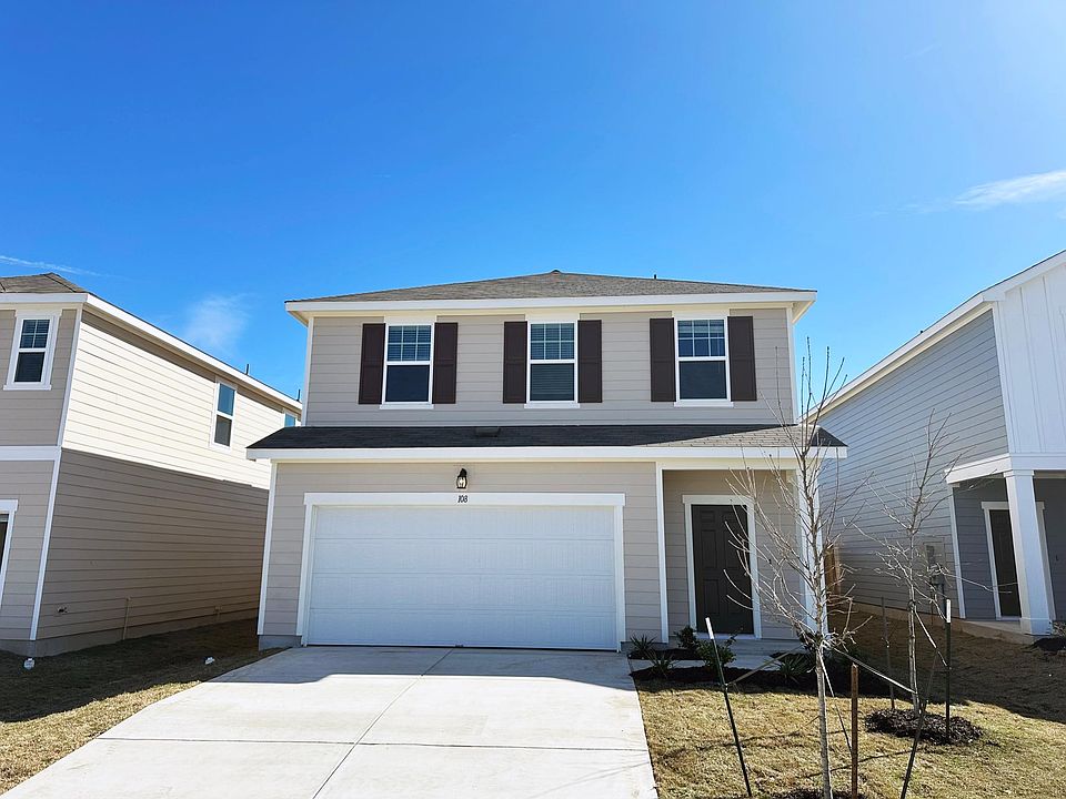 Outside view of the house. 2 car garage with parking on the driveway and entry on the right.