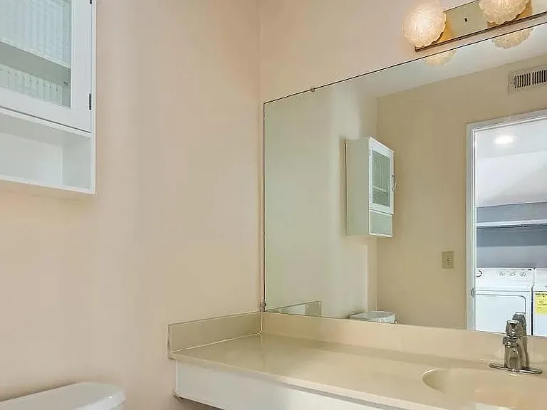 half bathroom facing the washing machine and dryer